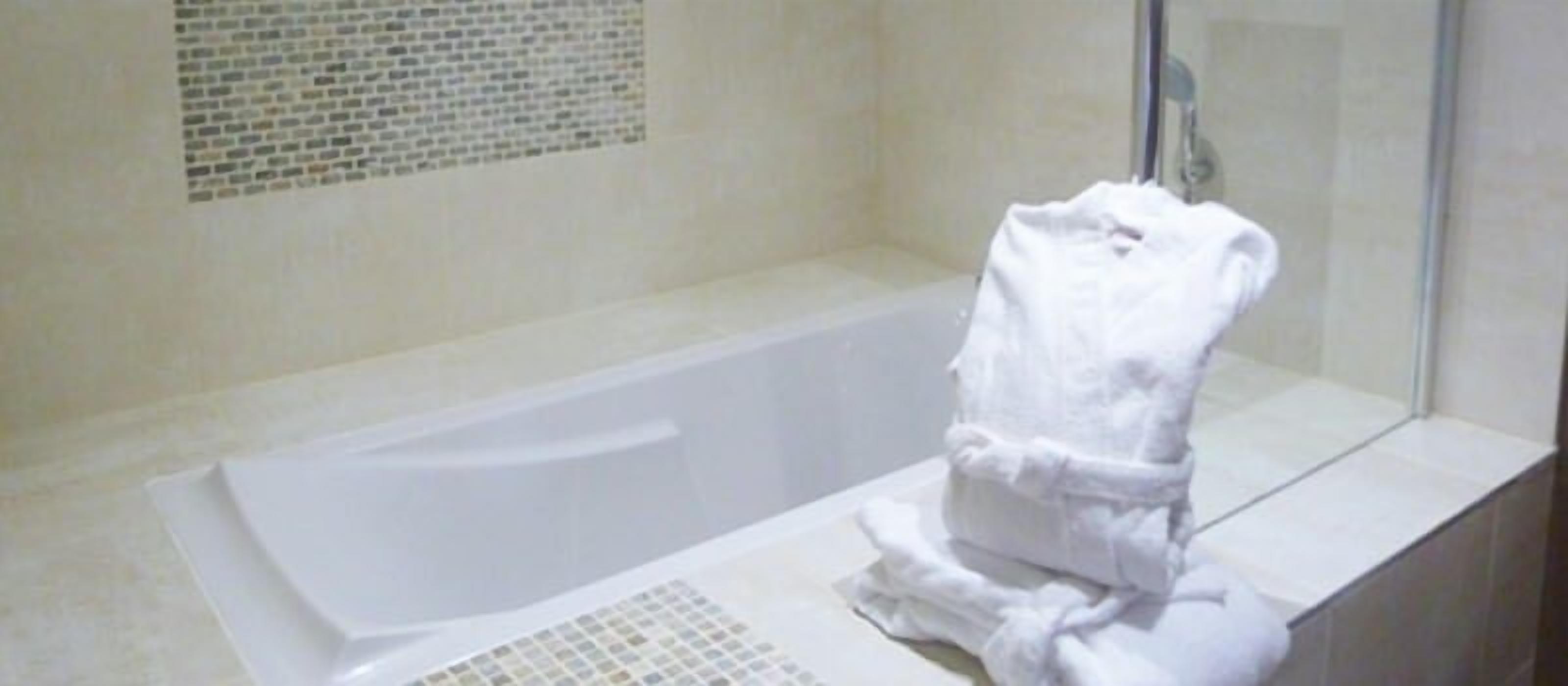A bathroom with a bathtub and a towel rack.