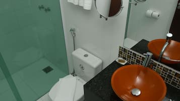 Um banheiro com vaso sanitário, pia com cuba laranja, área de chuveiro e espelho.