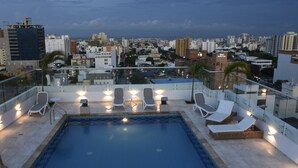 A rooftop pool area with lounge chairs and a view of the cityscape. - Radisson Hotel Diamond Barranquilla (Barranquilla)