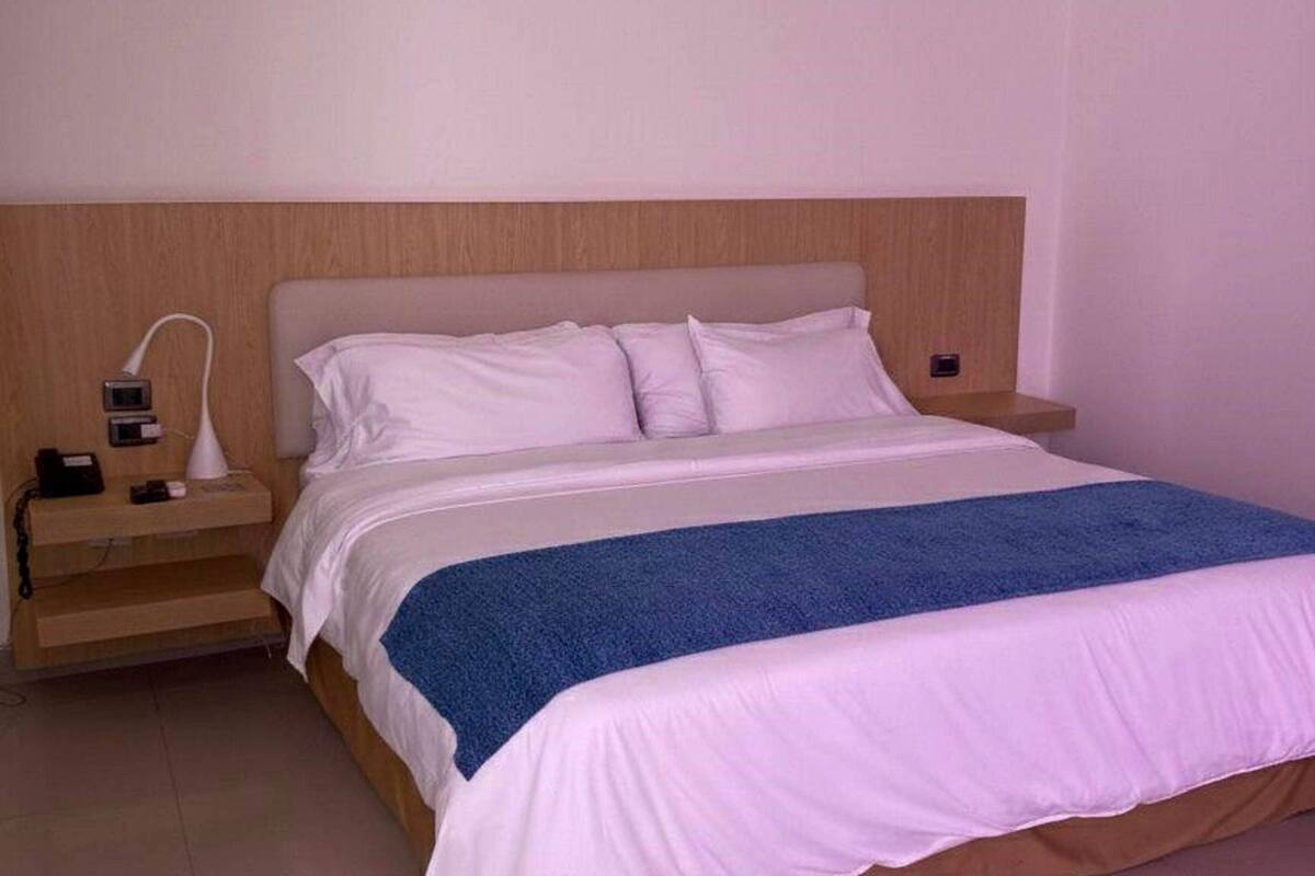 Ein Standard-Hotelzimmer mit einem Bett, Nachttischen und einem kleinen Tischchen.