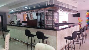 A bar area with a counter, bar stools, and a glass display. - Radisson Hotel Diamond Barranquilla (Barranquilla)
