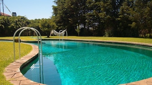 A swimming pool with a curved edge, a small bridge, and a hammock. - Quinta do Casalinho (Almeirim)