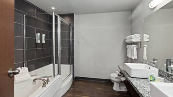 Un baño moderno con ducha envuelta en vidrio, una bañera independiente, un lavabo y un inodoro.