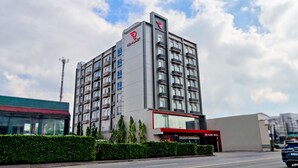 Ein modernes Hotelgebäude mit mehreren Etagen, Balkonen und dem gut sichtbaren Red Planet Logo.