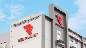 Un edificio con un diseño arquitectónico moderno, con el logotipo 'Red Planet' exhibido destacadamente en su fachada.
