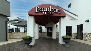 La entrada a Bourbon Street, con un arco rojo y dos macetas grandes con flores.