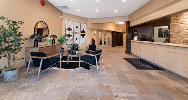 A reception area with a reception desk, seating area, and a potted plant.