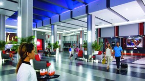 A spacious lobby with a checkered floor, seating areas, and a large screen displaying a video.