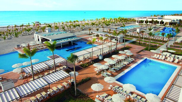 A resort with multiple swimming pools, sun loungers, and palm trees. - Hotel Riu Playa Blanca - All Inclusive (Rio Hato)