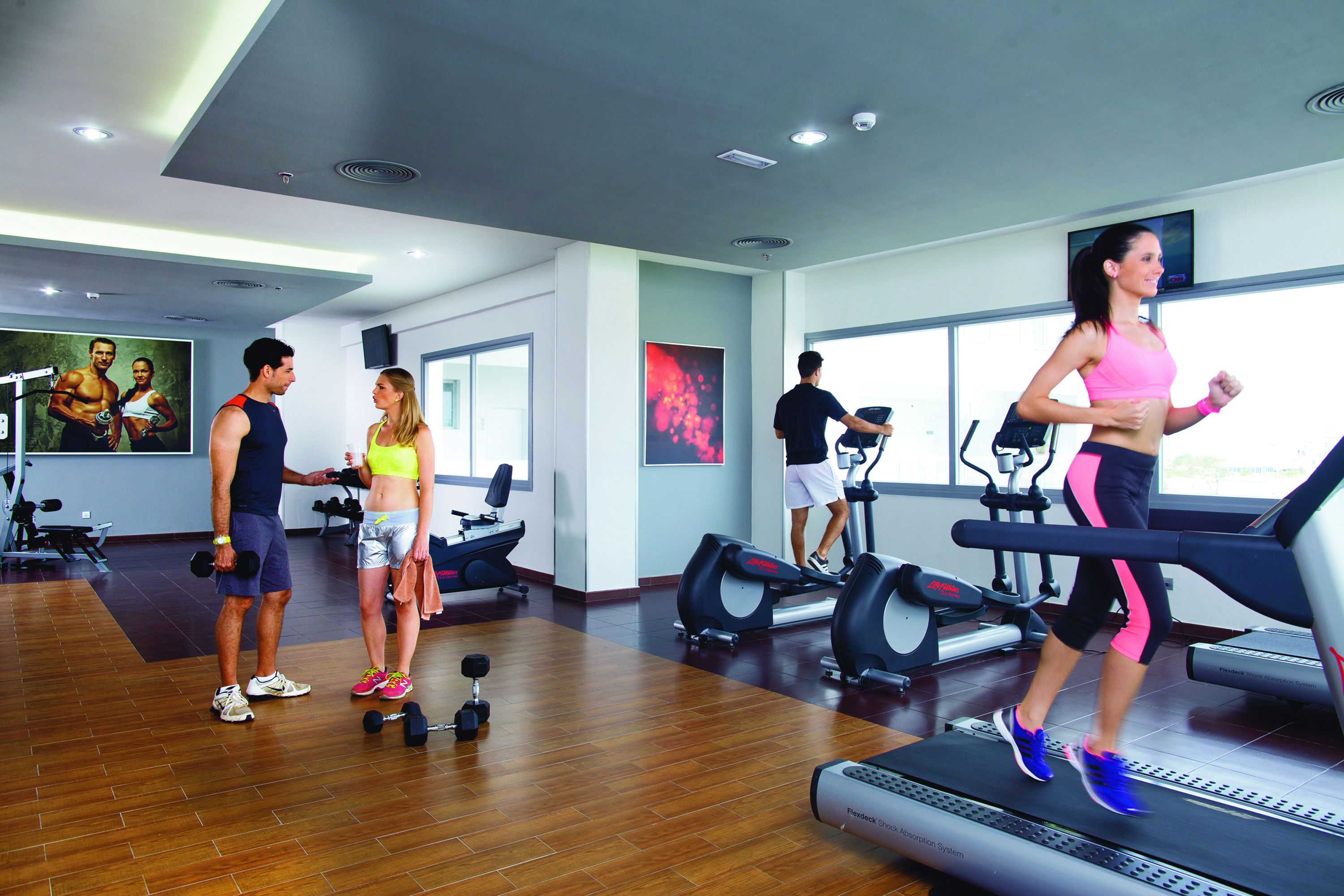 A gym with treadmills, dumbbells, and exercise equipment.