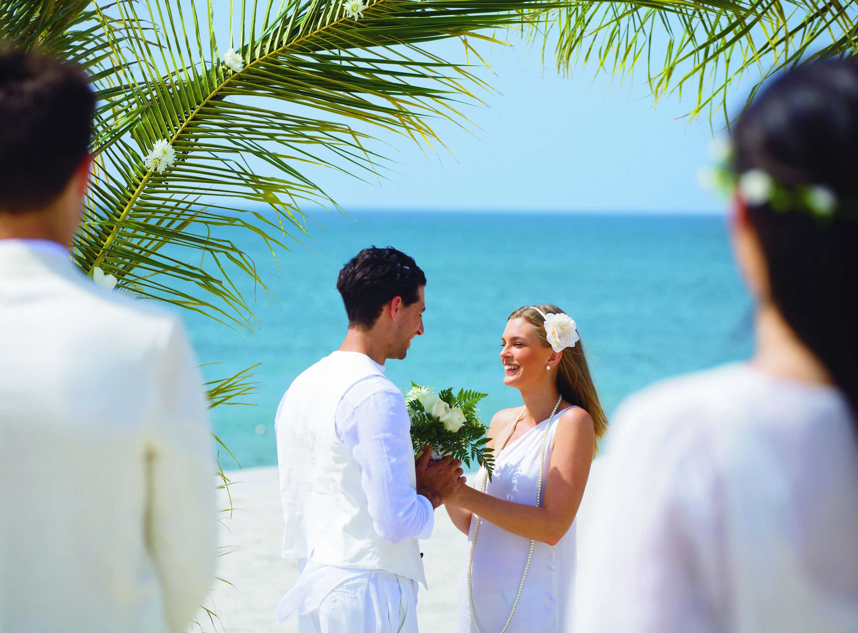 Una ceremonia de boda en la playa con una vista despejada del océano.