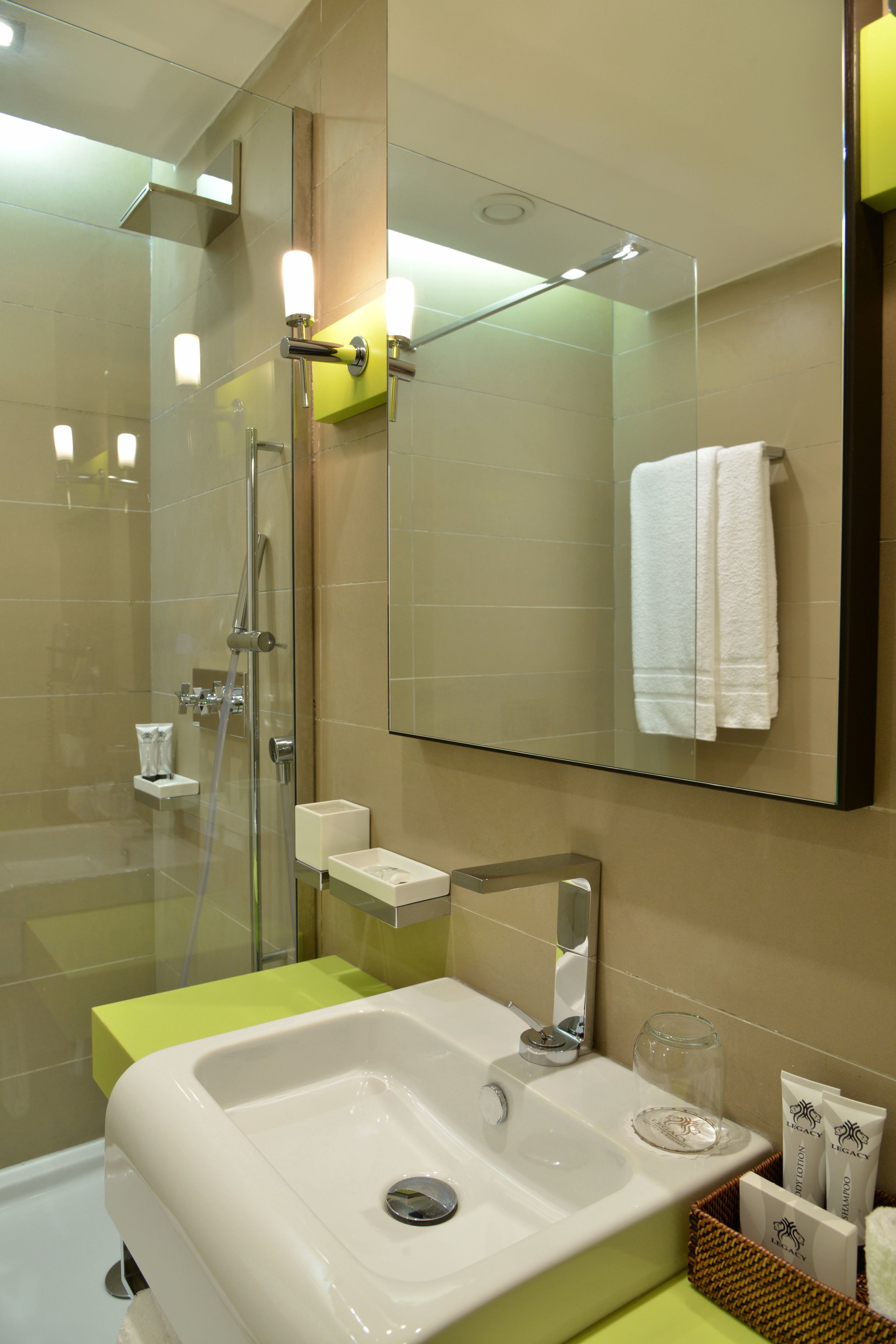 A modern bathroom with a glass-enclosed shower, a white sink, and a mirror above it.