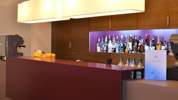 A bar area with a wooden wall and a purple shelf displaying various bottles.
