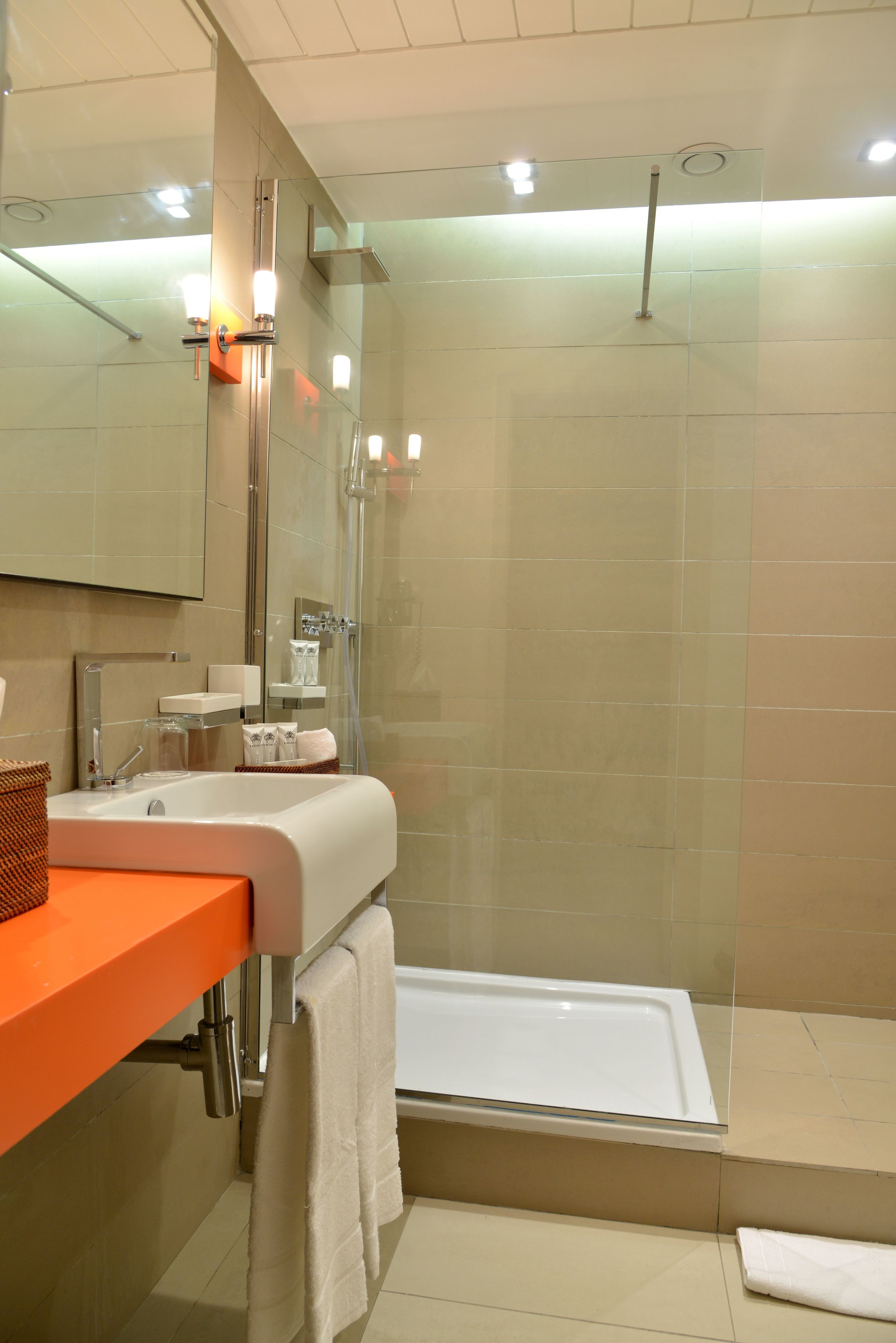 Een moderne badkamer met een douchecabine van glas, een badkuip en een wastafel met spiegel.