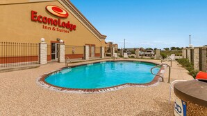 A swimming pool area with a hotel sign, poolside chairs, and a fenced walkway. - Econo Lodge Inn & Suites Bridgeport (Bridgeport)