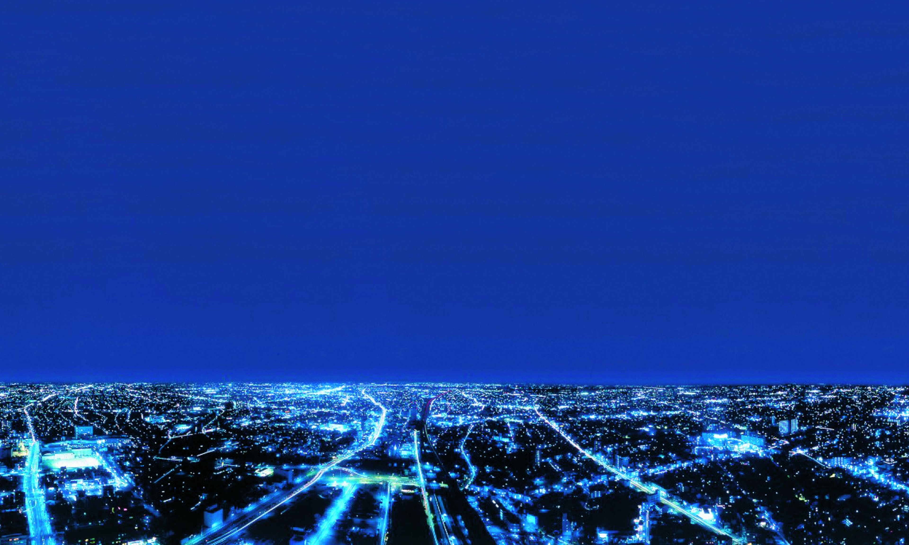 Un paisaje urbano nocturno con calles e edificios iluminados.