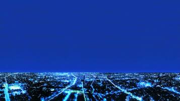 Un paisaje urbano nocturno con calles e edificios iluminados.