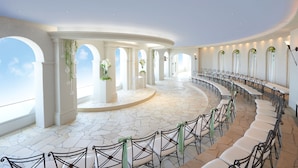 A spacious indoor venue with a curved seating arrangement, white columns, and large windows allowing natural light. - Okura Act City Hotel Hamamatsu (Hamamatsu)