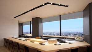 A modern kitchen with a large island, bar stools, and a city view through large windows. - Okura Act City Hotel Hamamatsu (Hamamatsu)