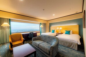 A hotel room with a large bed, two bedside tables, a sofa, a desk, and a view of the city. - Okura Act City Hotel Hamamatsu (Hamamatsu)