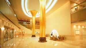 A spacious lobby with high ceilings, large golden columns, and a polished marble floor. - Okura Act City Hotel Hamamatsu (Hamamatsu)