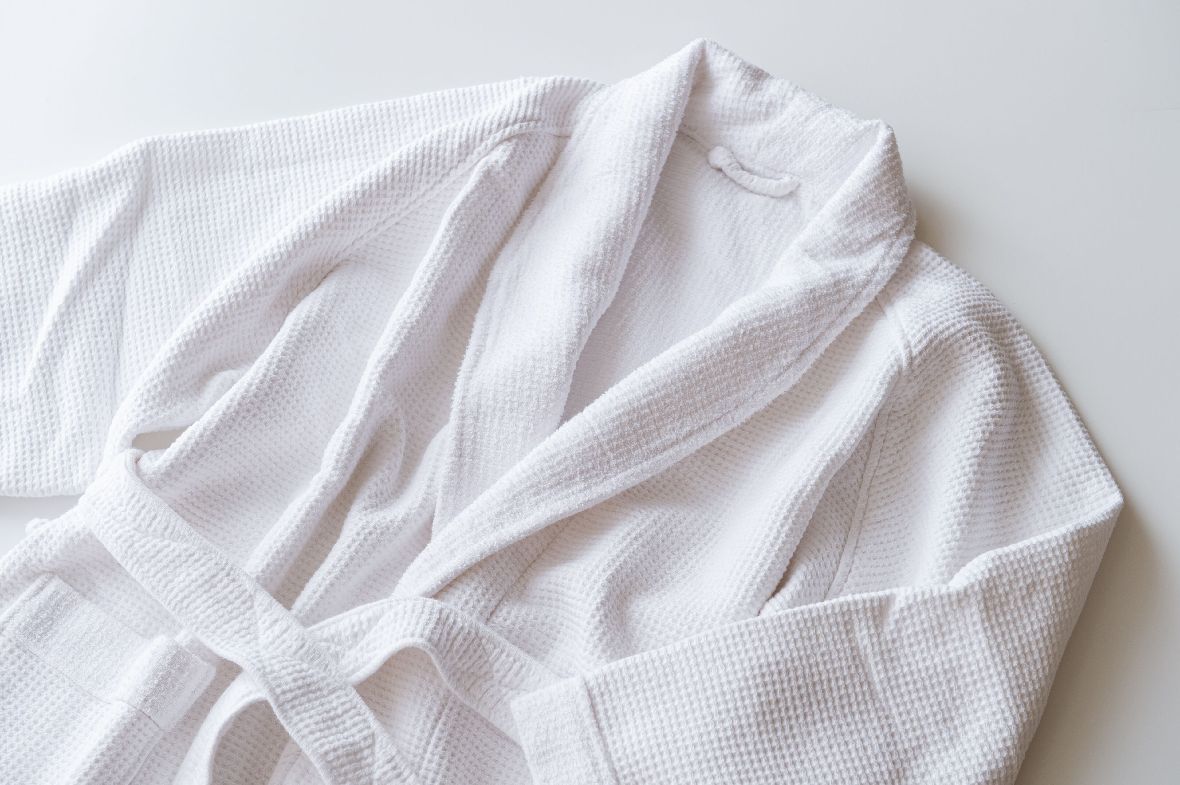 A white bathrobe laid out on a surface.