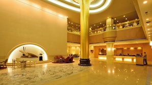 A spacious lobby with a grand piano, seating area, and a large decorative column. - Okura Act City Hotel Hamamatsu (Hamamatsu)