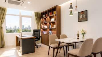 A modern office space with a desk, office chair, bookshelf, dining table with chairs, and a city view.