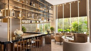 A modern bar area with shelves of liquor bottles, a marble countertop, and comfortable seating. - G8 Center Hotel Saigon (Ho Chi Minh City)