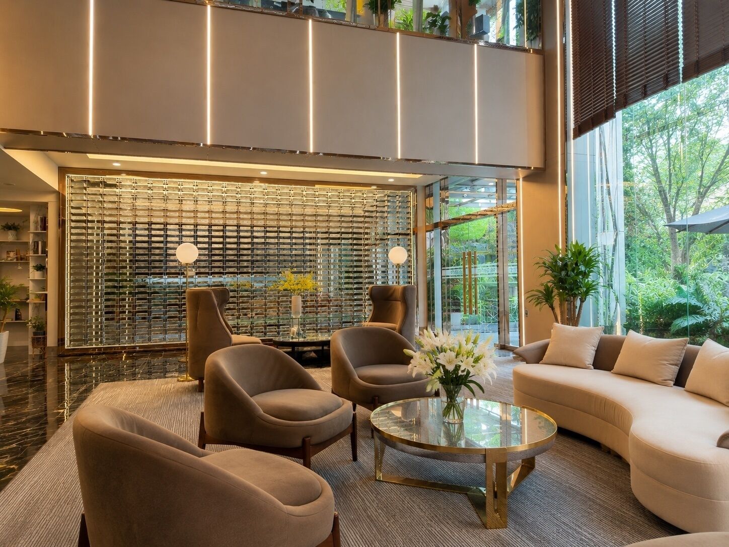 A modern interior with a glass partition, seating area, and a view of greenery.