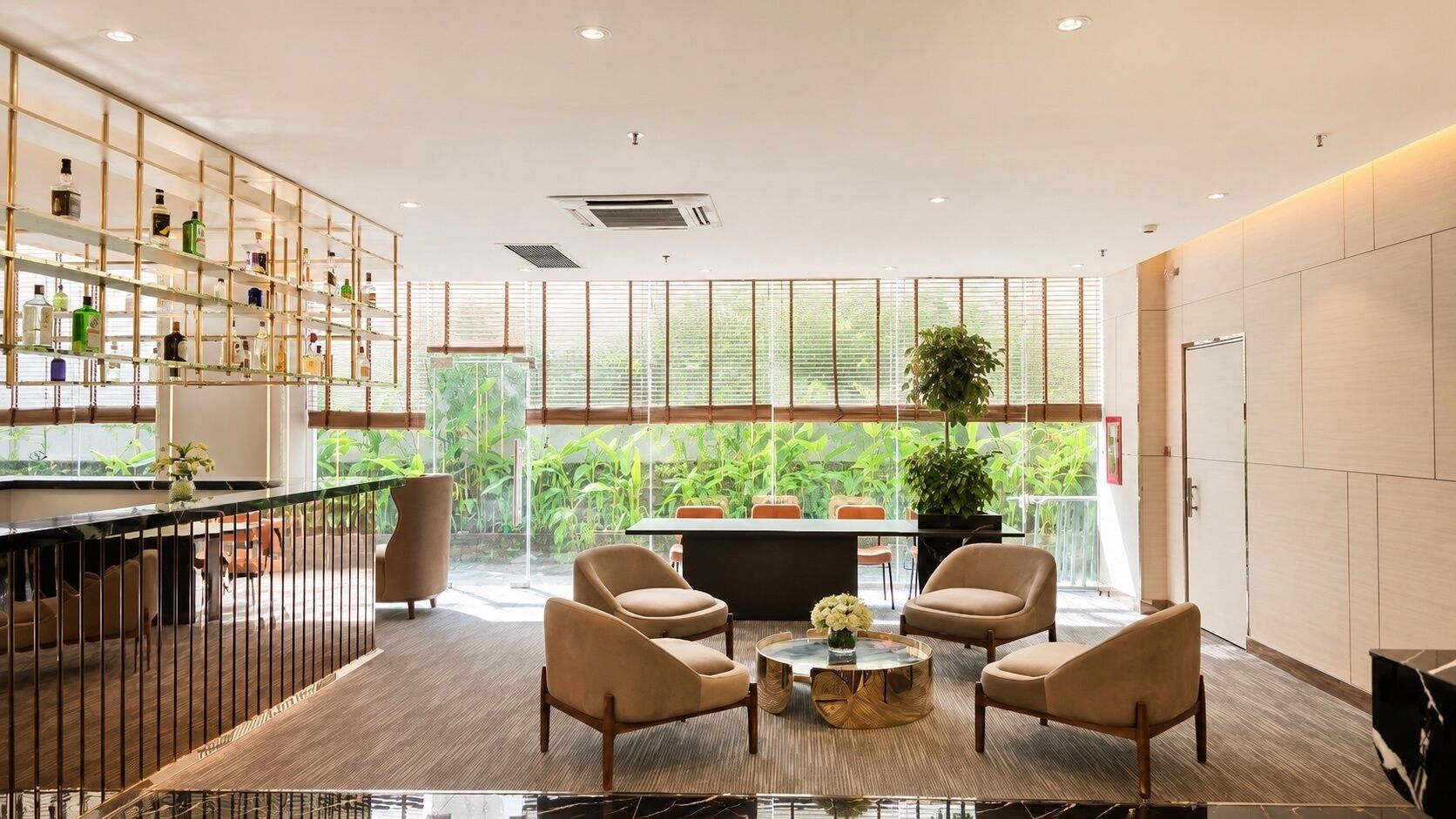 A modern interior with a bar area, seating, and large windows with a view of greenery.