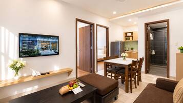Family Deluxe City View | Woonruimte | Een 32-inch ledtelevisie met kabelzenders en een televisie