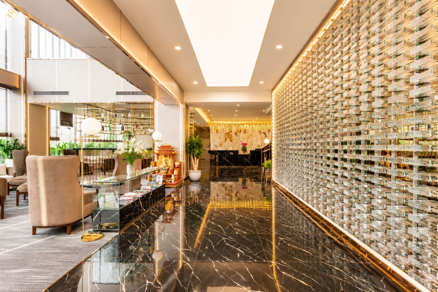 A modern lobby with a marble floor, seating area, reception desk, and a decorative wall with a grid pattern.