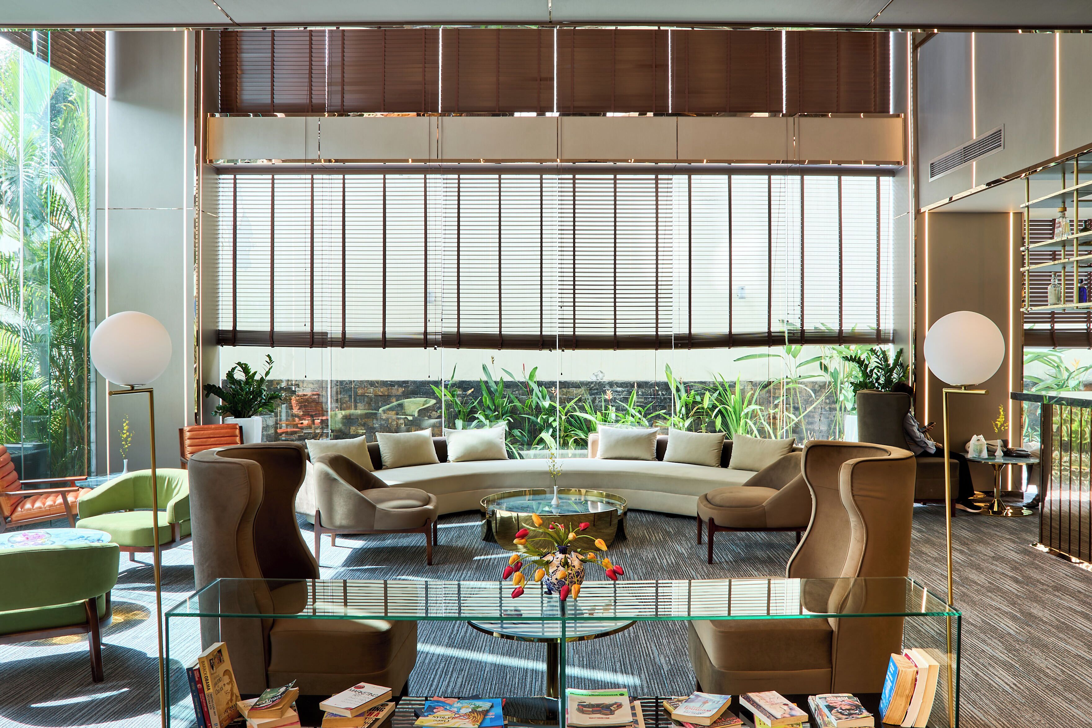Un salon moderne comprenant un canapé, des fauteuils, une table basse et une bibliothèque.
