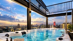 A rooftop hot tub with a city view, a welcome sign, and toiletries on a tray. - G8 Center Hotel Saigon (Ho Chi Minh City)