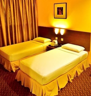 A hotel room with two single beds, a nightstand with a lamp, and a framed picture on the wall. - YMCA Kuala Lumpur (Kuala Lumpur)