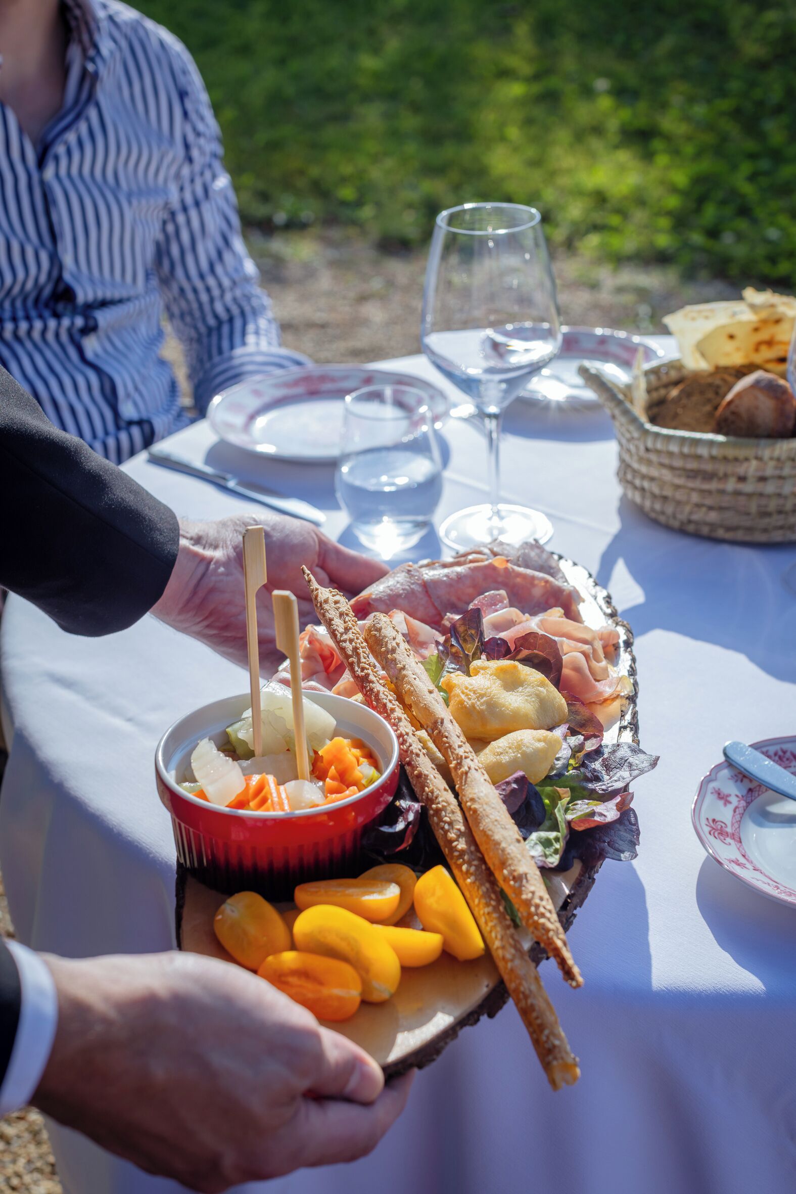 Una mesa dispuesta para una comida con diversos alimentos, incluyendo pan, queso y frutas.