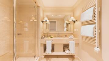 Un baño moderno con cabina de ducha de vidrio, tocador doble y perchero.
