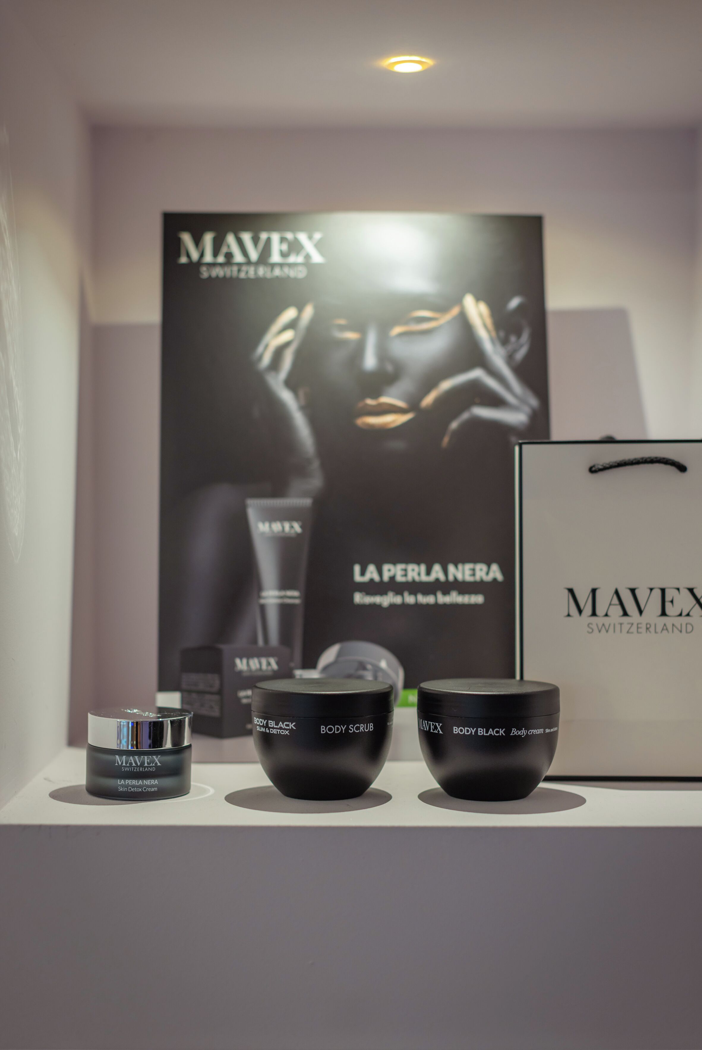 Eine Präsentation von Hautpflegeprodukten der Marke Mavex Switzerland, darunter Körperpeelings und Cremes, in einem Verkaufsraum.