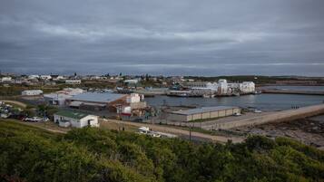 A coastal industrial area with warehouses, a dock, and a road leading to a residential area.
