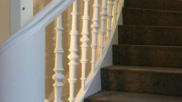 A staircase with white balusters and dark carpeted steps.
