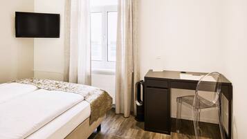 Ein Hotelzimmer mit Bett, Schreibtisch und Stuhl.