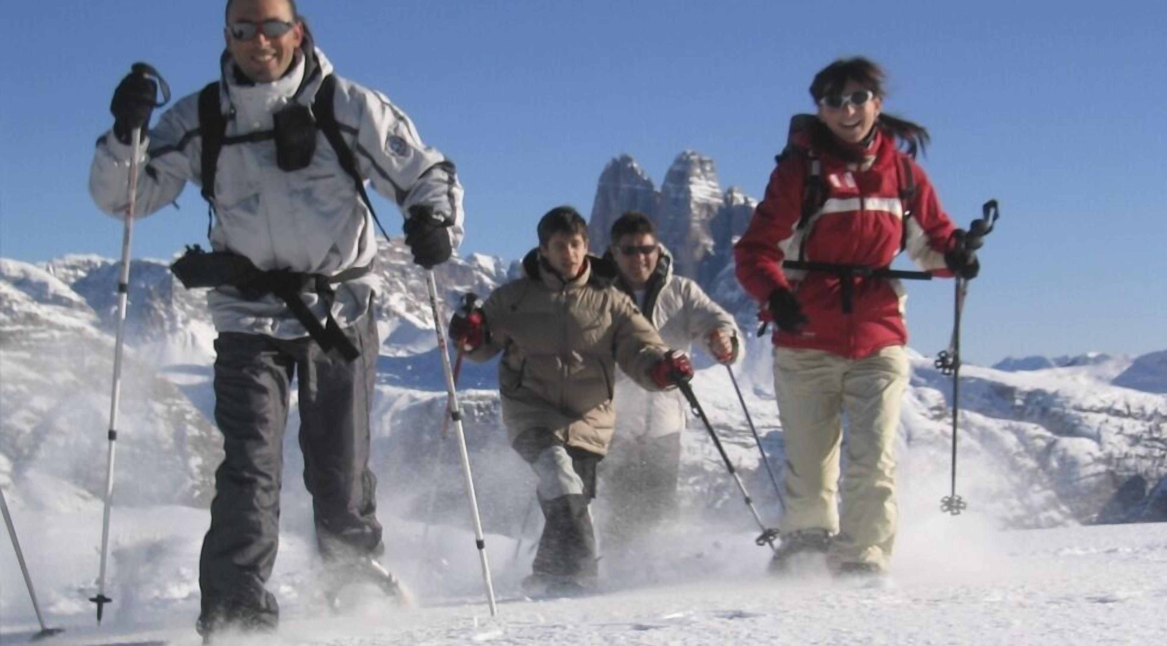 Un grupo de personas esquiando en una montaña nevada bajo cielos despejados.