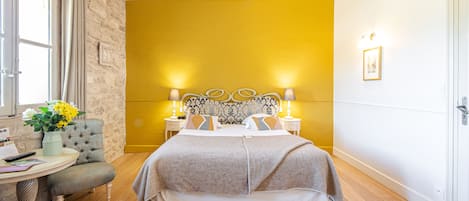 Une chambre à coucher avec un lit, des tables de chevet, une chaise et une fenêtre.