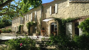 Un bâtiment en pierre doté de nombreuses fenêtres et d’une entrée abritée.