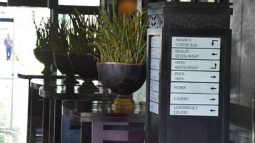 Un cartel con indicaciones hacia diferentes servicios, como cafetería, restaurantes, zona de piscina y centro de convenciones.