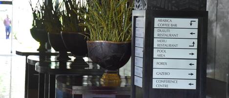 A signpost with directions to various facilities including a coffee bar, restaurants, a pool area, and a conference center.