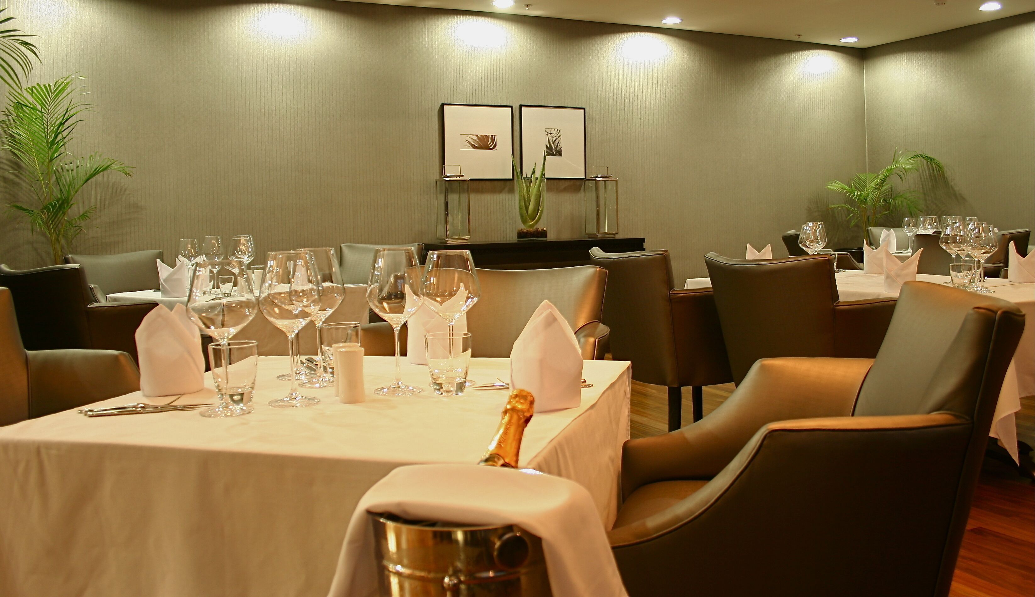 A dining area with tables set for a meal, chairs, and a decorative centerpiece.