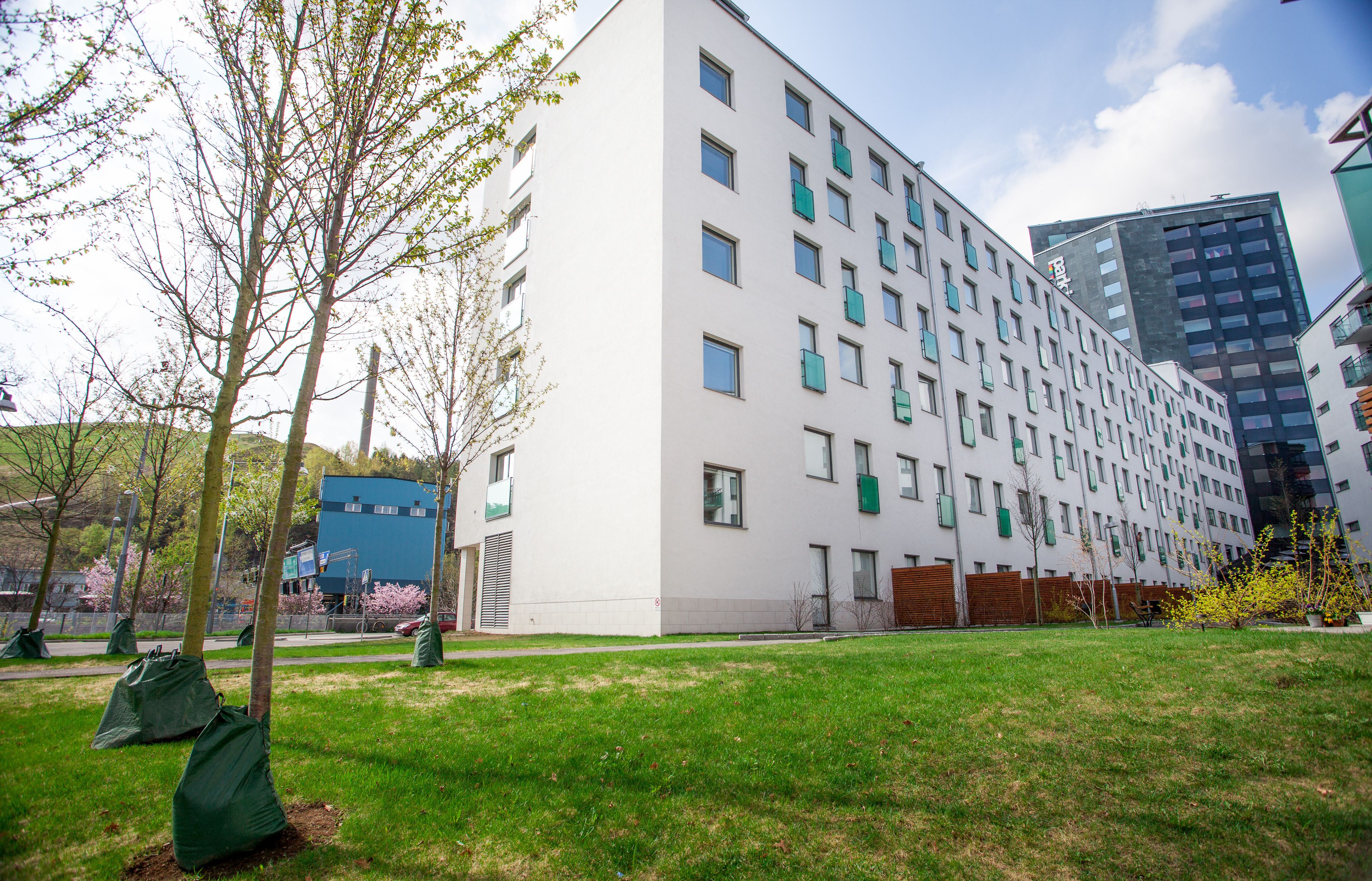 A modern multi-story building with a flat facade, large windows, and a flat roof.