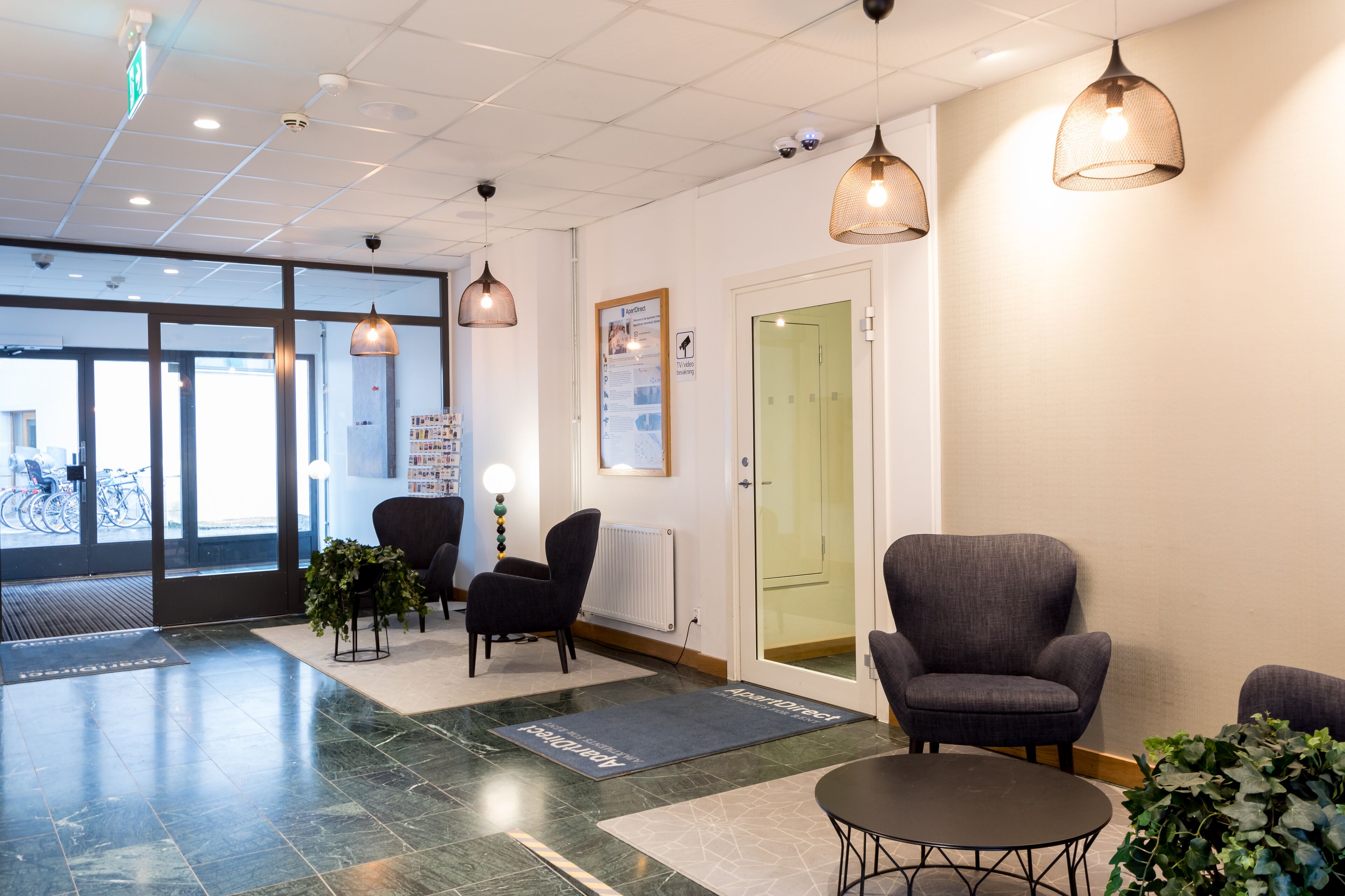 A reception area with a reception desk, seating, a bulletin board, and a door to a waiting area.
